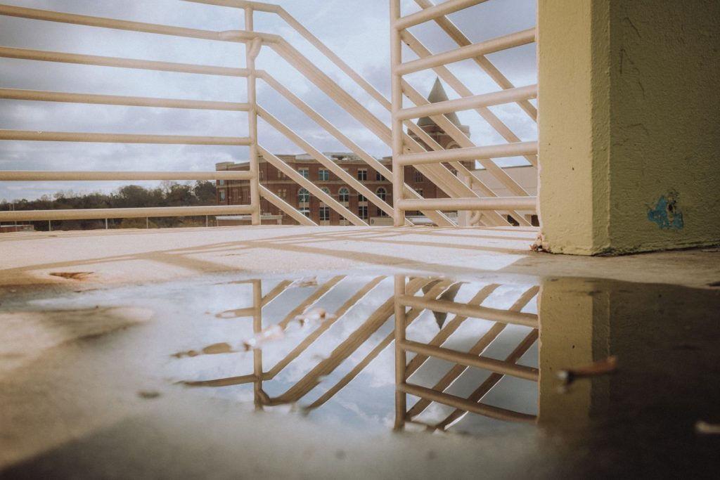 Standing water pooled on an urban rooftop surface after rain.